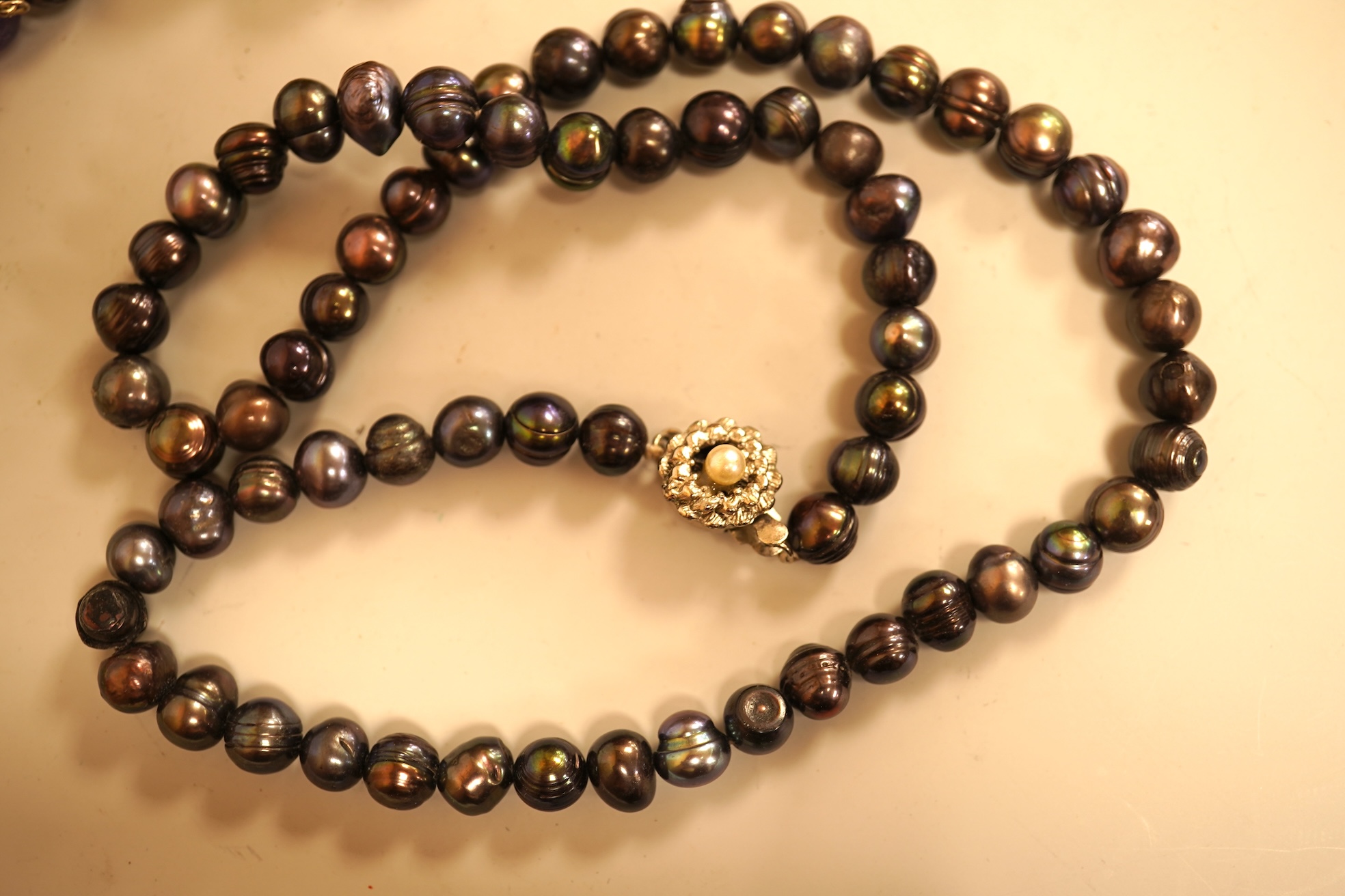 A small group of sundry jewellery including a simulated amber necklace and a multi strand coral bead necklace, etc.